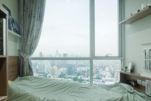 Bedroom with large window and city view