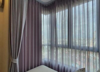 Cozy bedroom with large windows and sheer curtains