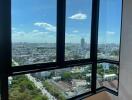 Urban city view through large glass windows from a high-rise building