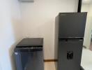 Modern kitchen area with a refrigerator and a wine cooler