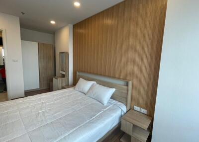 Modern bedroom with wooden accent wall and double bed