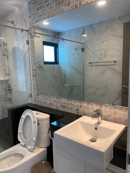 Modern bathroom with white fixtures and large mirror