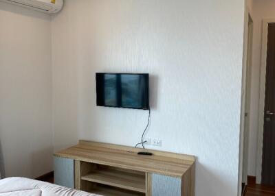 Modern bedroom with wall-mounted TV and air conditioning