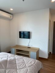 Modern bedroom with wall-mounted TV and air conditioning