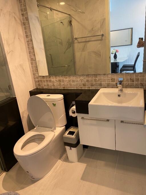 Modern bathroom with toilet, sink, and shower