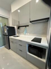 Modern kitchen with gray cabinets, induction cooktop, and built-in appliances