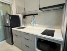 Modern kitchen with gray cabinets, induction cooktop, and built-in appliances