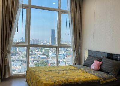 Bright bedroom with large windows and city view