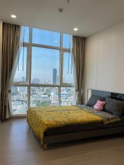 Bright bedroom with large windows and city view