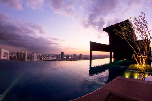 Stunning rooftop pool with cityscape view at sunset