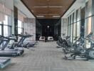 Modern equipped gym with exercise machines and large windows