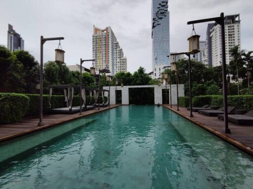 Outdoor swimming pool in a residential area with city skyline in the background