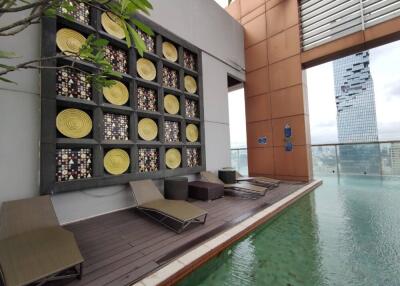 Rooftop pool with lounge chairs and decorative wall