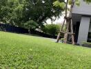 Well-maintained green lawn with trees and a partial view of a modern building