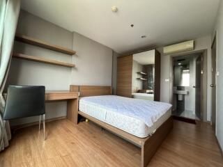 Modern bedroom with wooden flooring and a large bed