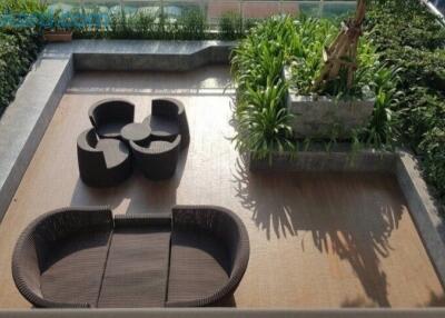 Aerial view of a stylish outdoor patio with rattan furniture and lush greenery