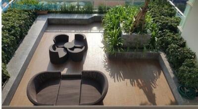 Aerial view of a stylish outdoor patio with rattan furniture and lush greenery