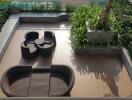 Aerial view of a stylish outdoor patio with rattan furniture and lush greenery