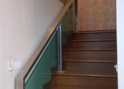 Interior staircase with wooden steps and glass railing