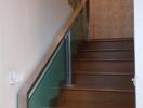 Interior staircase with wooden steps and glass railing