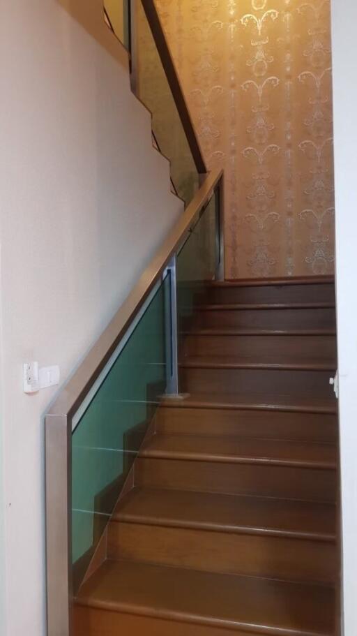 Interior staircase with wooden steps and glass railing