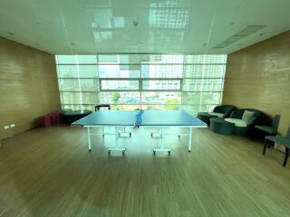 Spacious recreational area with a ping pong table and city view