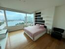 Spacious bedroom with large windows and city view