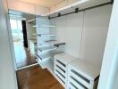 Modern walk-in closet with built-in shelving and drawers