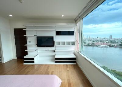 Spacious bedroom with built-in shelves and a large window view