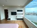 Spacious bedroom with built-in shelves and a large window view