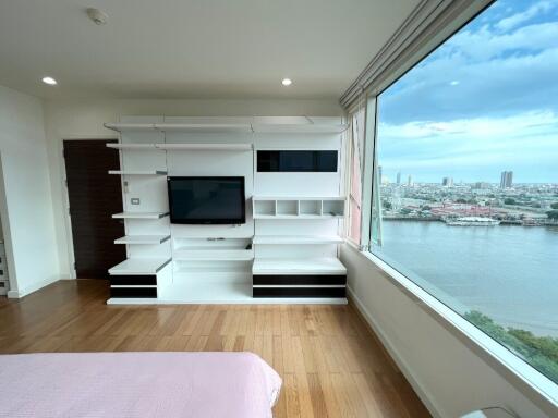 Spacious bedroom with built-in shelves and a large window view