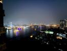 night view of an urban skyline with a river and ferris wheel