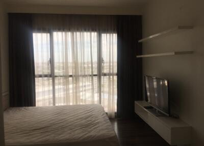 Bedroom with large window and TV