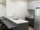 Modern kitchen with high chairs and built-in appliances