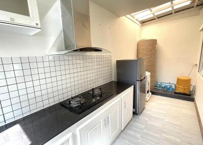 Modern kitchen with stove, tiled backsplash, and appliances