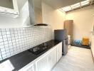 Modern kitchen with stove, tiled backsplash, and appliances