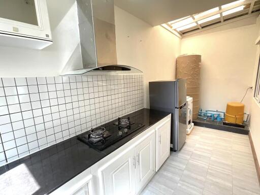 Modern kitchen with stove, tiled backsplash, and appliances