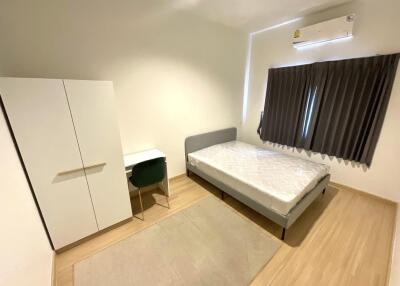 Minimalist bedroom with bed, wardrobe, desk, and air conditioner