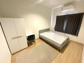 Minimalist bedroom with bed, wardrobe, desk, and air conditioner