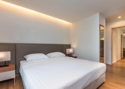 Modern bedroom with a double bed, side tables, and warm lighting