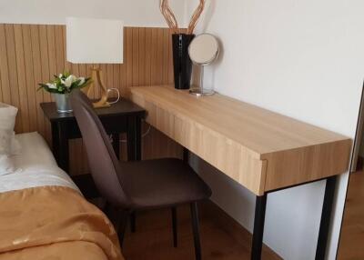 Bedroom with bedside table, lamp, chair, and wooden desk