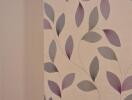 Interior wall with decorative purple and grey leaf wallpaper