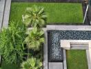 Aerial view of an outdoor area with palm trees, greenery, and a tiled water feature