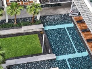 Outdoor pool area with seating and palm trees