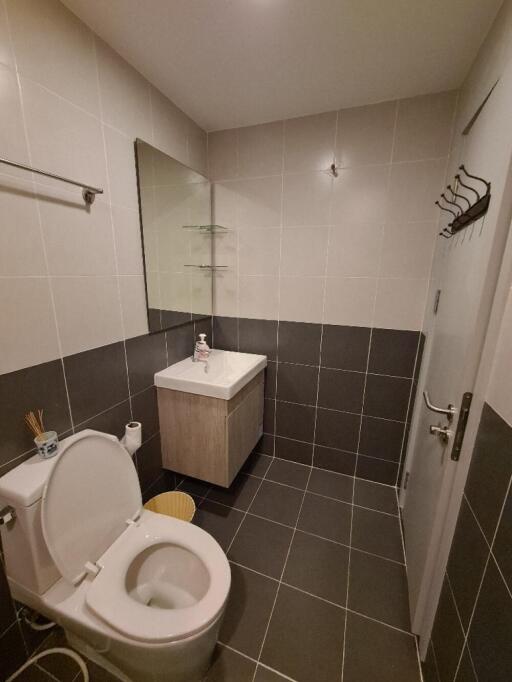 Modern bathroom with toilet, sink, and wall mirror