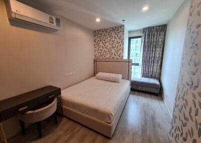 Modern bedroom with wood flooring, large bed, desk and air conditioner