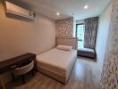 Modern bedroom with wood flooring, large bed, desk and air conditioner