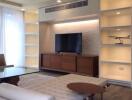 Modern living room with wall-mounted TV and built-in shelves