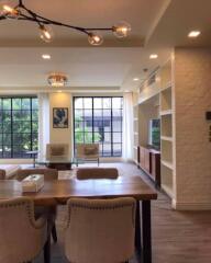 Modern living room with large windows, elegant lighting, and comfortable seating