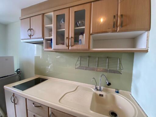 A well-organized kitchen with wooden cabinets, sink, and stove